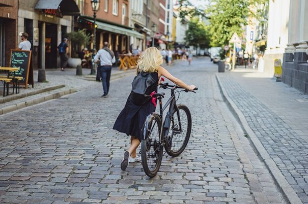 Free photo young sports woman on a bicycle in a european city. sports in urban environments.